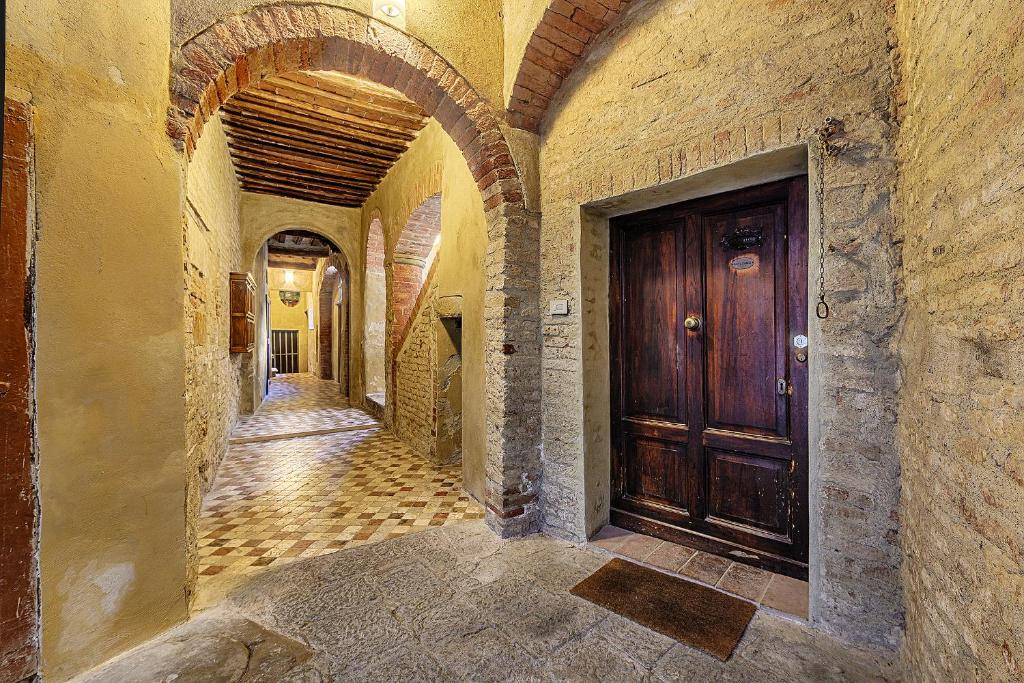 an alley way with a wooden door in a building at Elehome2 nel cuore della città in Siena