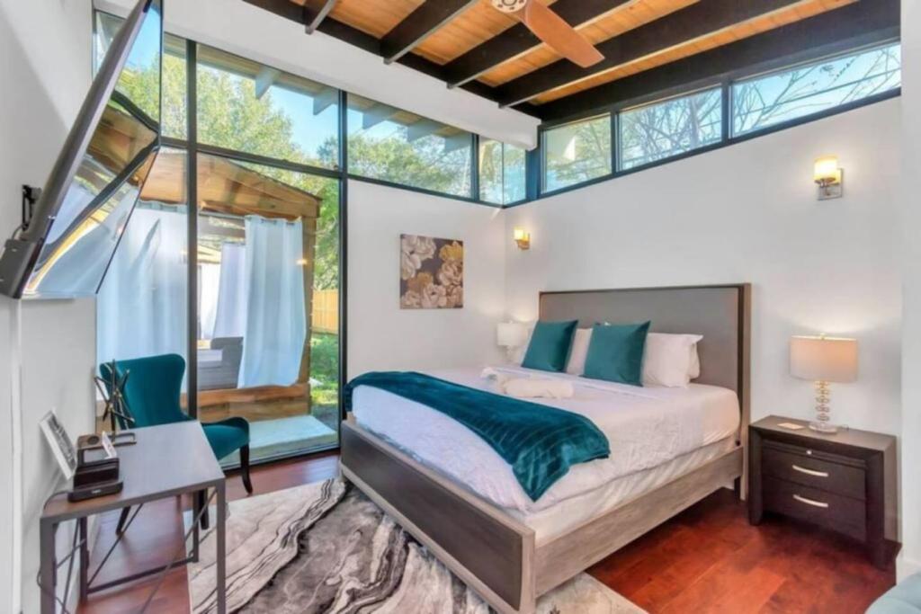 a bedroom with a bed and a desk and window at Resort Style Vacay HeatedPool Hottub and Cabanas in Houston
