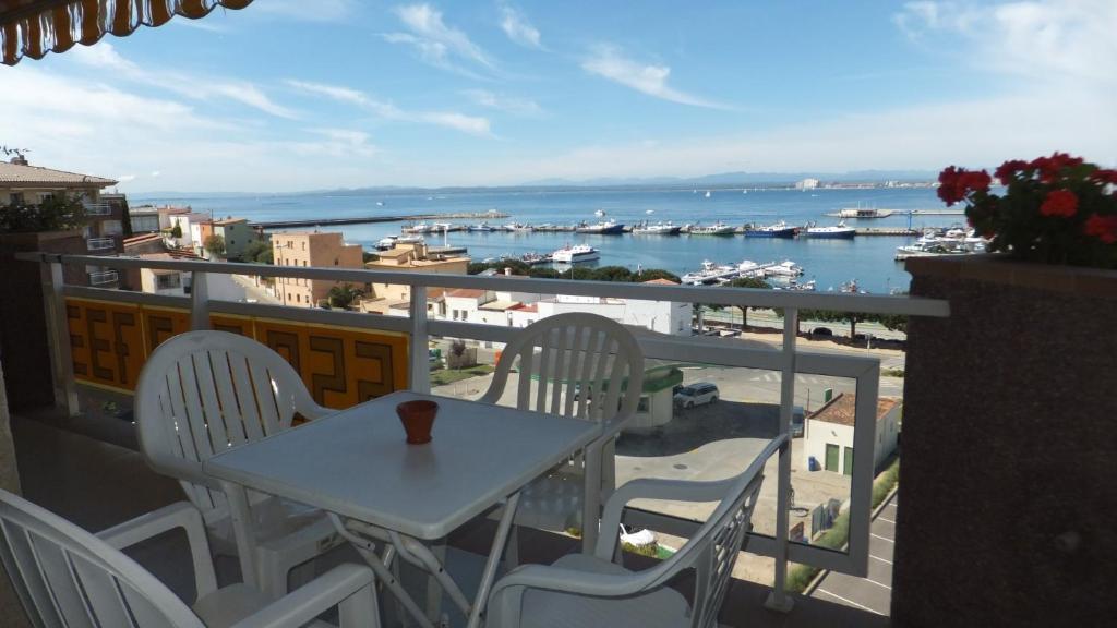 ロザスにあるRoc Mar 2 5C - Apartamento cerca del centro y de la playa - terraza con vistas al mar y al puertoのテーブルと椅子、水辺の景色を望むバルコニー