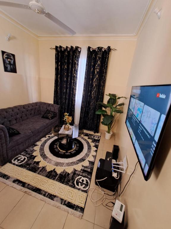 sala de estar con sofá y TV de pantalla plana en Petra Homes, en Mombasa