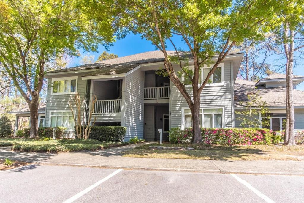 a large white house with trees in front of it at Tidewater- Teal lake #2521 in North Myrtle Beach