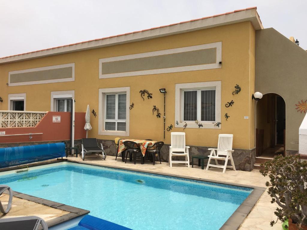 una casa con piscina frente a ella en Villa Azure, en Caleta de Fuste