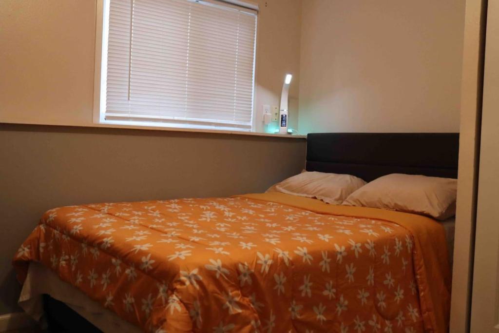 - une chambre avec un lit doté d'une couette en orange et d'une fenêtre dans l'établissement AZGuestHouse at Mill Full Bedroom-Shared Bathroom5, à Fountain