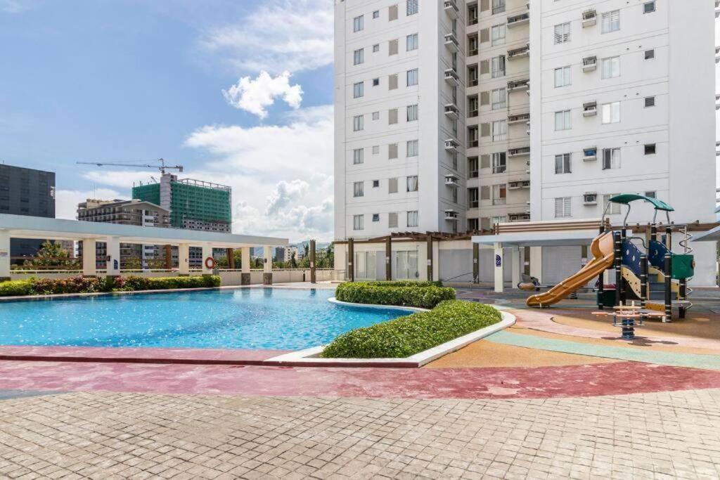 una gran piscina con un tobogán en un edificio en 1-Bedroom IT Park Avida Cebu, en Cebú