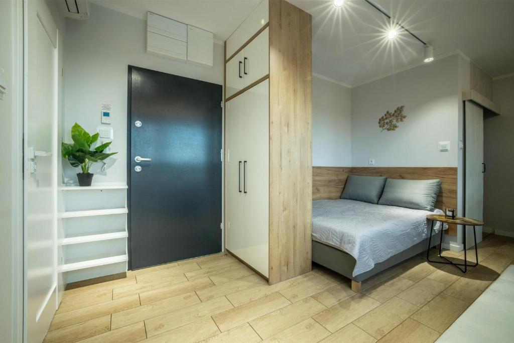 um quarto com uma cama e uma porta de correr em WiguryTower Apartaments 63' em Lódź