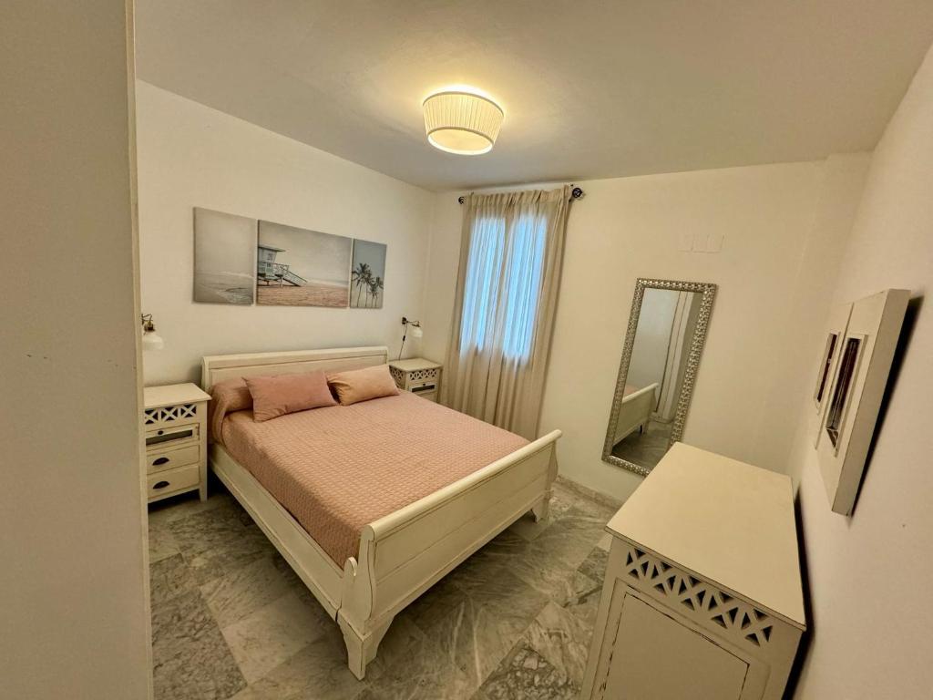 a bedroom with a bed and a mirror at Apartamento Universal in La Línea de la Concepción