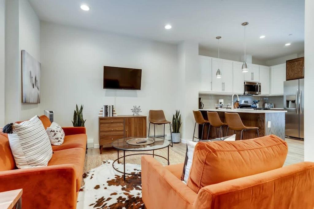 a living room with orange furniture and a kitchen at The Honeysuckle Homestead Georgetown Living in Georgetown