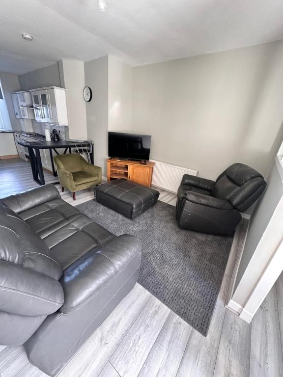 a living room with a leather couch and a table at Great Northern Apartment in Aberdeen