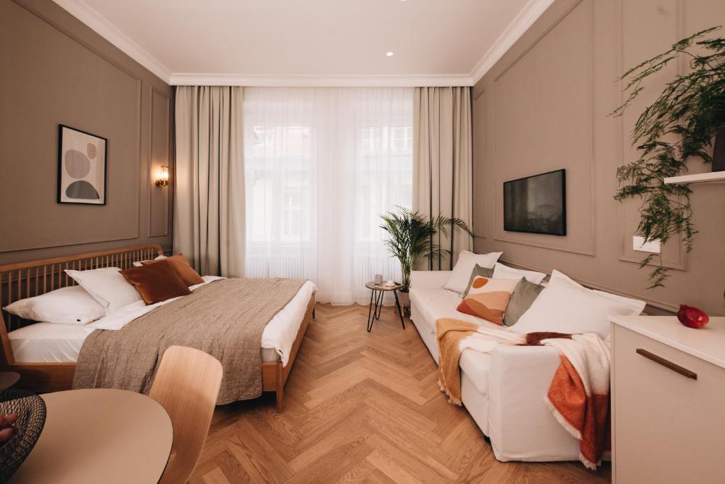 pokój hotelowy z dwoma łóżkami i kanapą w obiekcie Stylish new apartment in Prague with A/C w Pradze