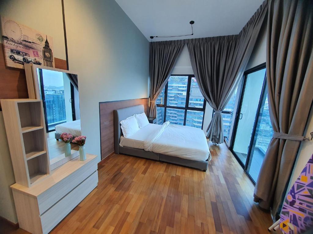 a bedroom with a bed and large windows at Reizz Homestay By Classy in Kuala Lumpur