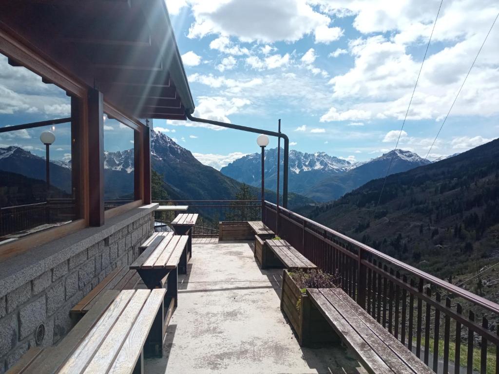a balcony with benches and a view of mountains at Stella Alpina Fabrezza in Saviore dellʼAdamello