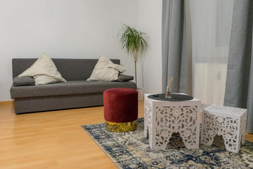 ein Wohnzimmer mit einem Sofa und 2 Tischen in der Unterkunft Serenity Apartment 45m2 Free Parking in Leoben