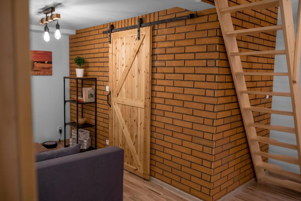 a room with a brick wall with a wooden door at Apartmány ve Dvoře in Herálec