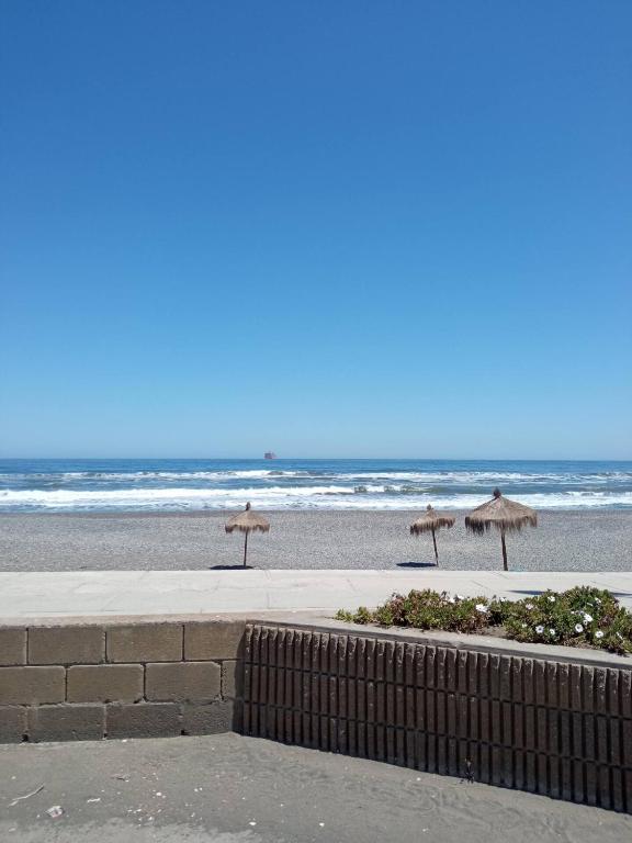 a beach with some umbrellas and the ocean at Hermoso Depto. Santo Domingo in Santo Domingo