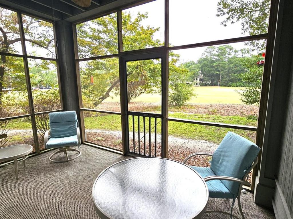 a screened in porch with two chairs and a table at Teal Lake 1413 in North Myrtle Beach