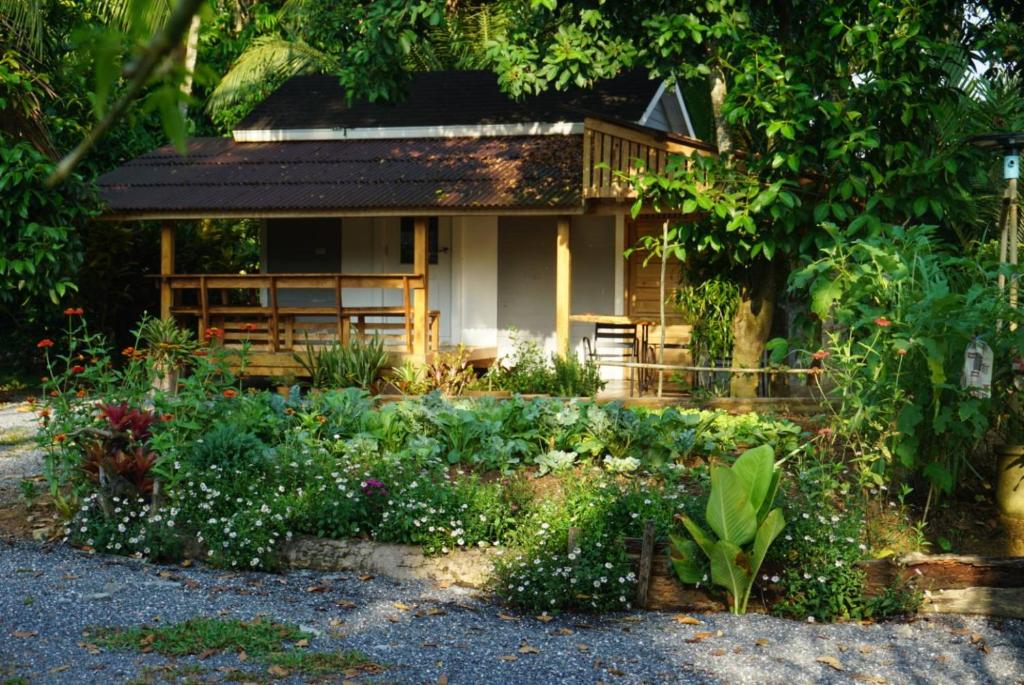 a house with a garden in front of it at Thong Tiny House in Phatthalung