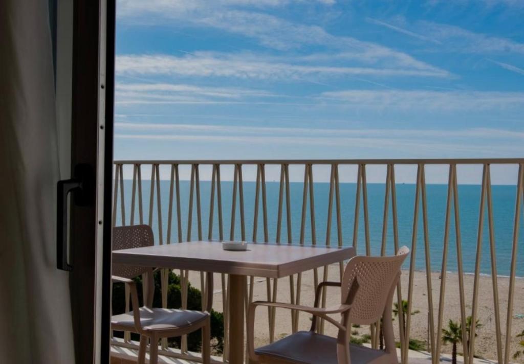 a table and chairs on a balcony with the ocean at Luli apartment Durrës in Durrës