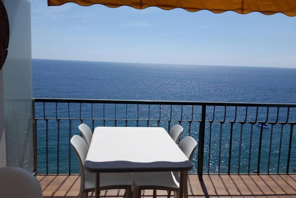 una mesa y sillas en un balcón con vistas al océano en Pis Embaixador 1a línea de mar, en Platja d'Aro