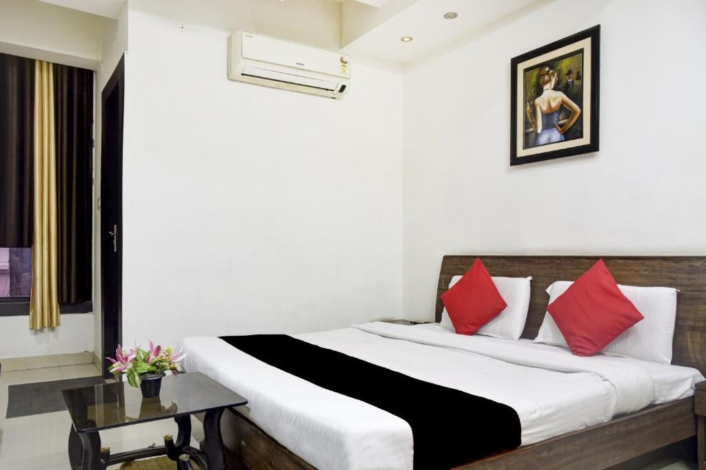 een slaapkamer met een groot bed met rode kussens bij Collection O 81293 Hotel Aditya Palace in Bhopal