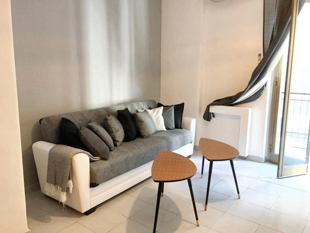 a living room with a couch and two stools at 4 bedrooms apartement with city view balcony and wifi at Catania 1 km away from the beach in Catania
