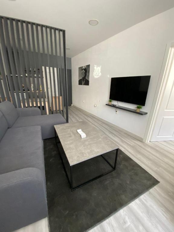 a living room with a couch and a flat screen tv at Apartman Kiara in Mostar