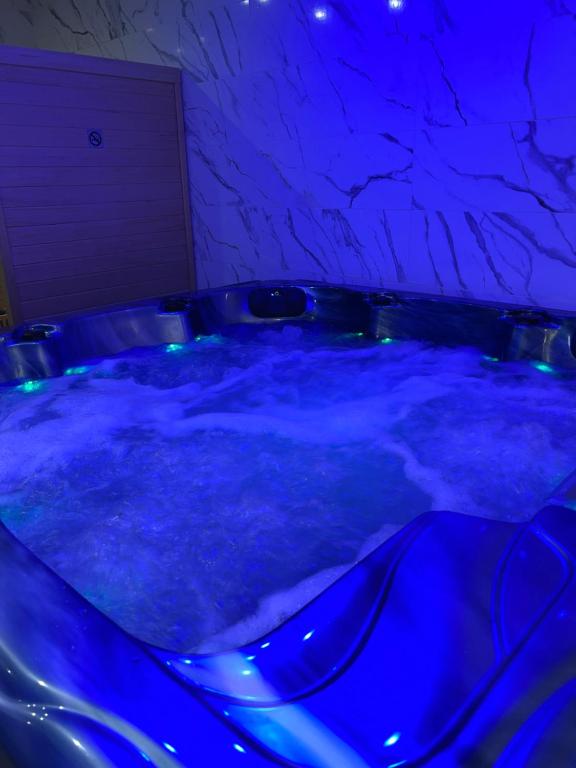 een blauwe hot tub met blauwe verlichting in een kamer bij La nuit de rêve Spa privatif Jaccuzi Sauna suite 1 in Crouy