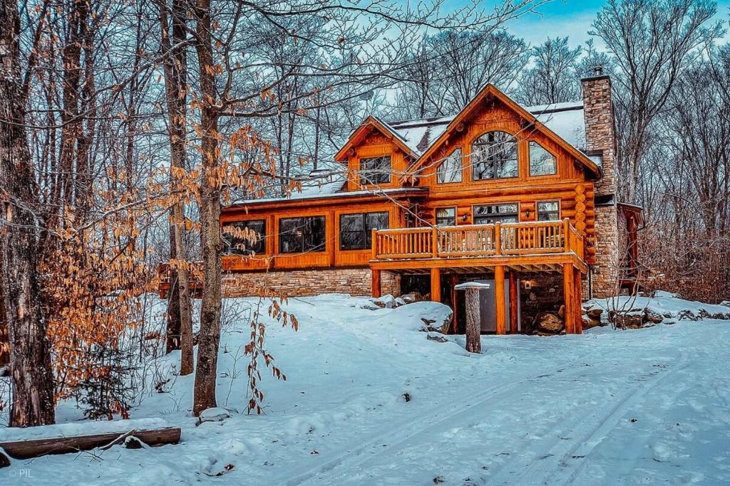 una gran casa de madera en el bosque en la nieve en CA Rhuddin en Labelle