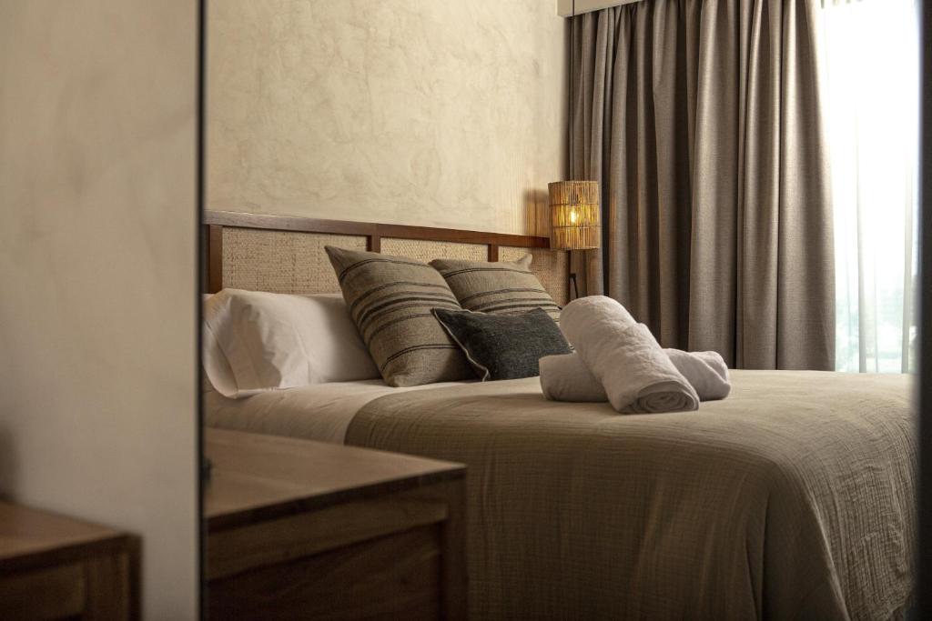 a bedroom with a bed with pillows and a window at Albades Hotel & Spa - Adults Only in Benicàssim
