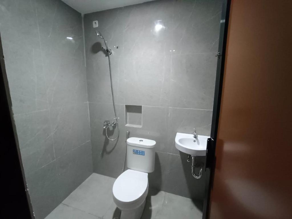 a bathroom with a toilet and a sink at Losmen cempaka in Sibengkok