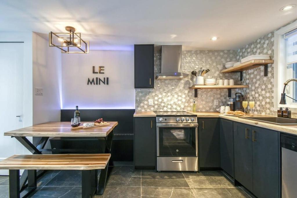 uma cozinha com armários azuis e uma mesa em Le mini chalet em Sainte Anne des Lacs