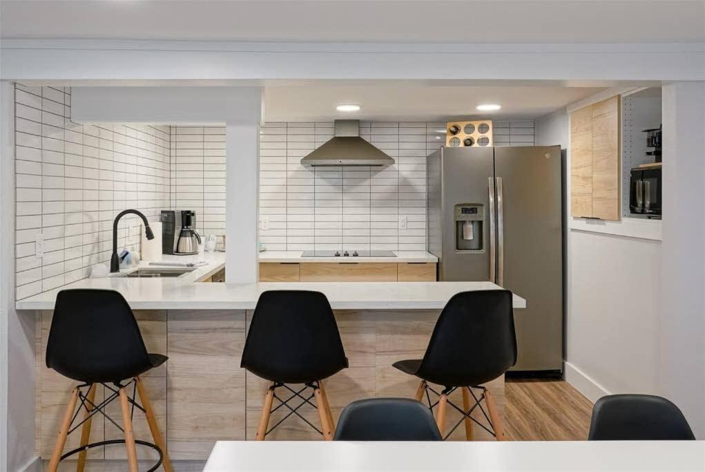 a kitchen with a counter with chairs and a refrigerator at #StayInMyDistrict St Johns Walk to dining & shops in Portland