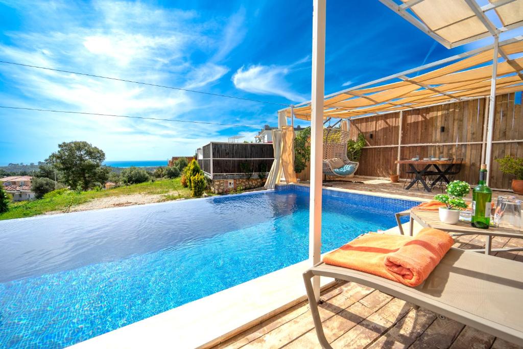 a villa with a swimming pool with a chair at Villa Patara Flower in Patara