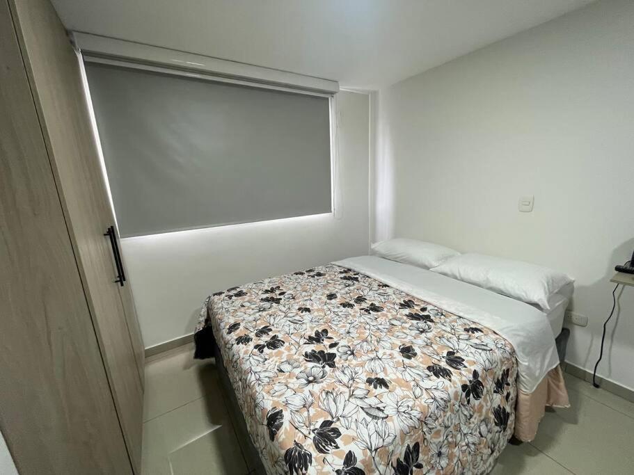 um pequeno quarto com uma cama e uma janela em Apartaloft en el centro 302 em Pereira