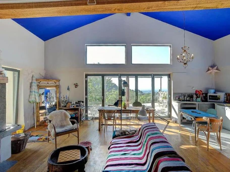een woonkamer met een blauw plafond en een tafel en stoelen bij Ardeche Nature 