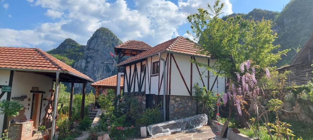 une petite maison avec des montagnes en arrière-plan dans l'établissement Golemi kamik Pirot Vlasi 4, à Pirot