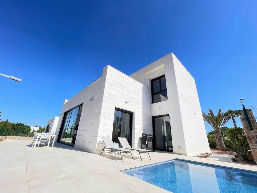 uma casa branca com uma piscina em frente em Modern 4 Bed Villa with Pool LC4 em Orihuela