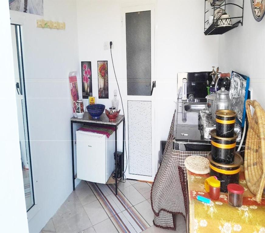 a small kitchen with a table and a stove at Studio near the sea for surfing lovers welcome in Safi