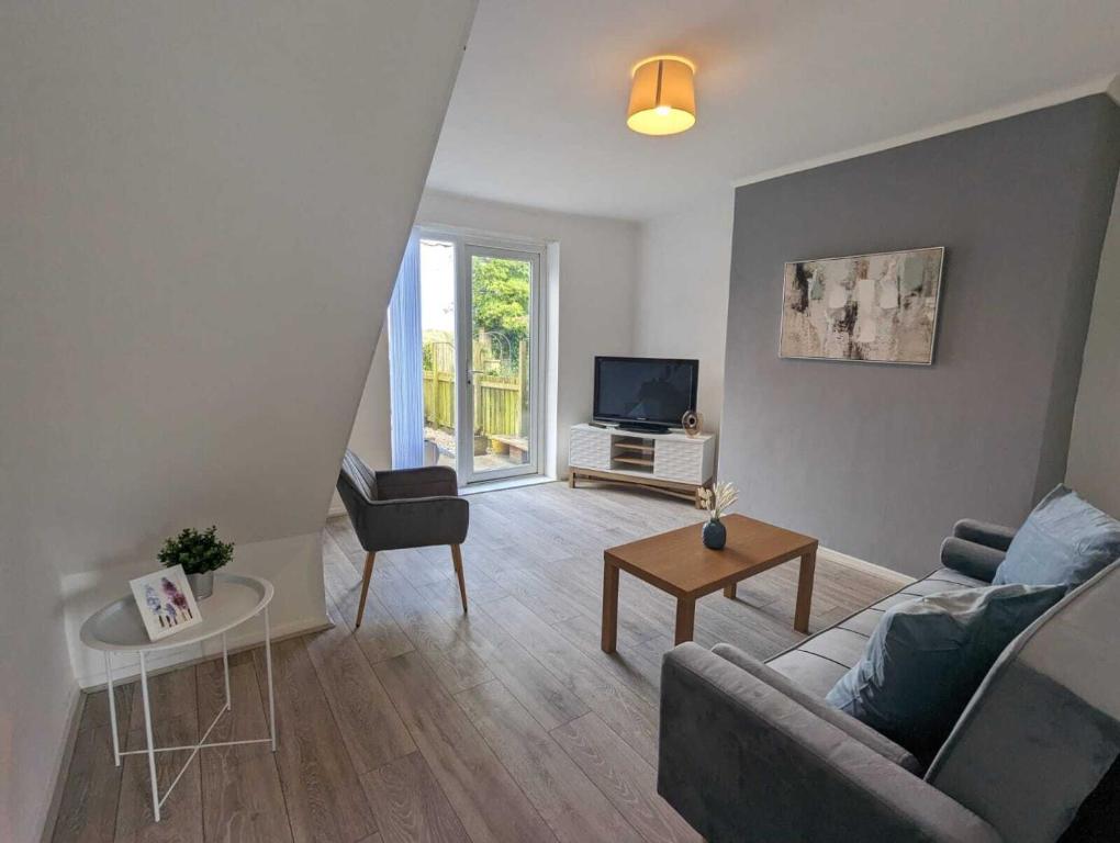 uma sala de estar com um sofá e uma televisão em Alexander Apartments Dudley em Seaton Burn