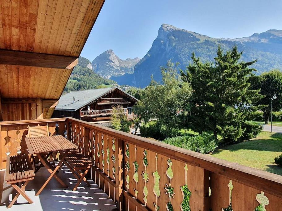 a balcony with a table and chairs and mountains at C11, 72m2, 3 bedrooms, next to the ski lift in Samoëns