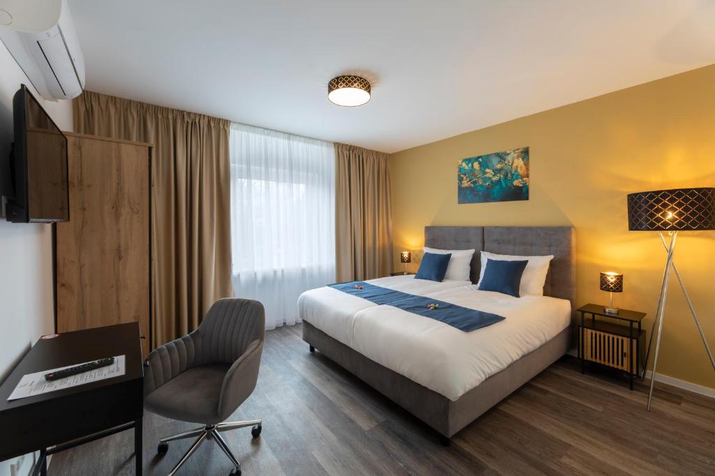 une chambre d'hôtel avec un lit et une chaise dans l'établissement VIU2 Suites, à Hanovre