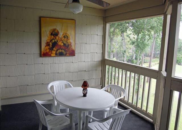 a white table and chairs on a porch with a window at Heron Lake 3232 in North Myrtle Beach