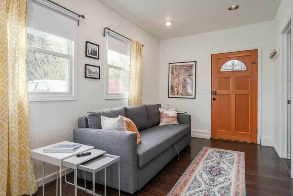 a living room with a gray couch and a door at #StayinMyDistrict Kenton Private Guest House in Portland