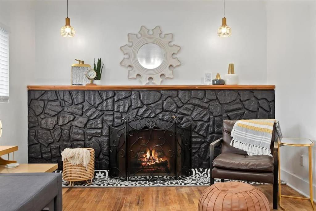 a living room with a fireplace with a chair and a mirror at #StayinMyDistrict Twin Falls Spanish-Boho Getaway in Twin Falls