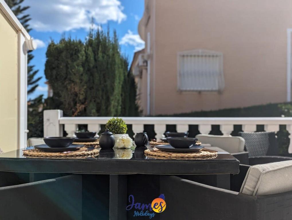 a table with bowls and plates on it on a patio at Cheerful 3 Bedroom Townhouse in El Galan EG2 in San Miguel de Salinas