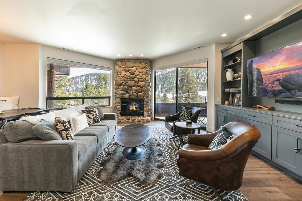 a living room with a couch and a fireplace at Stylish 2BD Condo - Walk to Palisades! in Olympic Valley