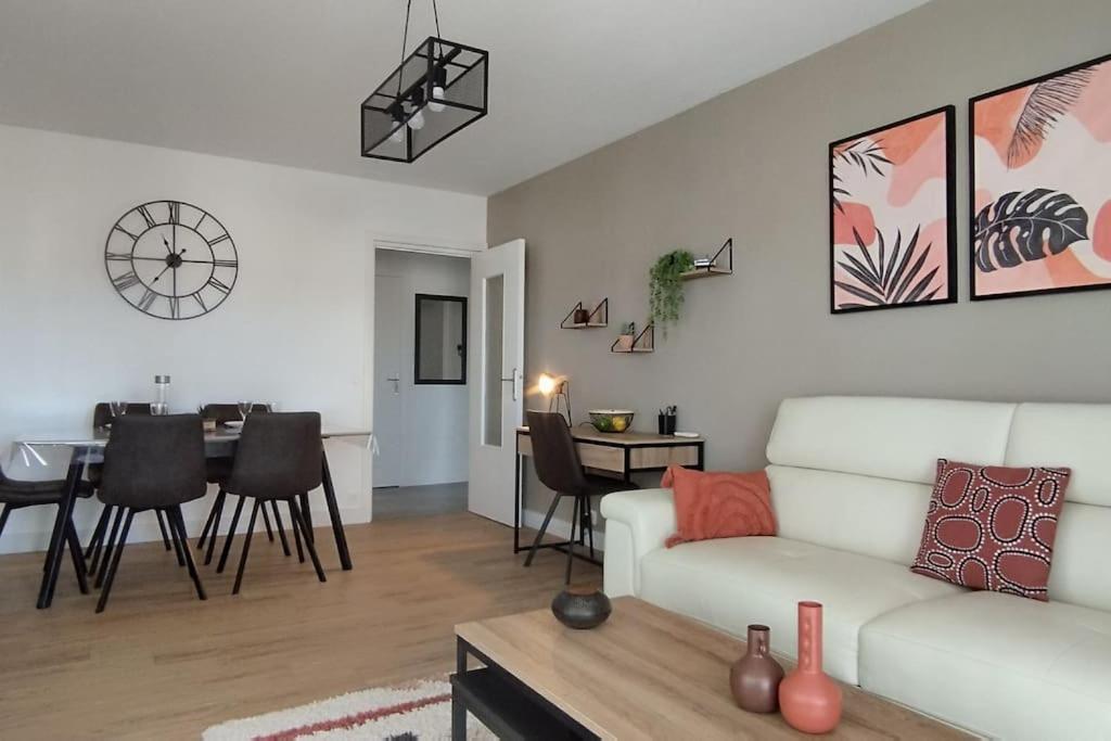 a living room with a white couch and a table at Les Géraniums, bel appartement rénové, proche plage et commerces in La Seyne-sur-Mer