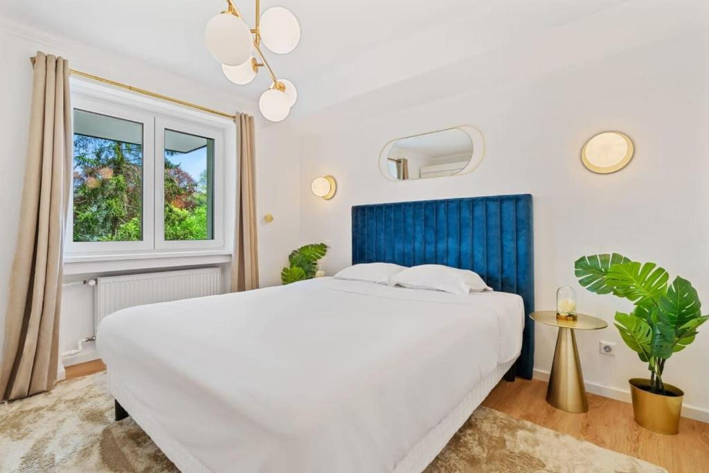Un dormitorio blanco con una cama grande y una ventana. en Chic 1BR Near Kirchberg & Luxembourg Centre, en Luxemburgo