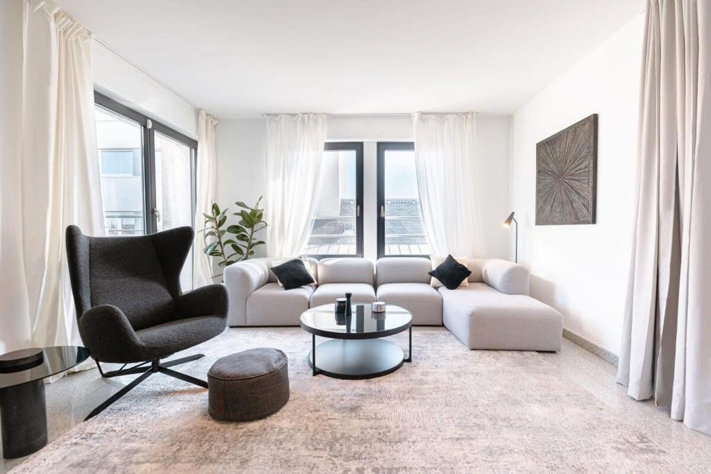 sala de estar con sofá, mesa y sillas en Luxurious Duplex Penthouse in Center-Gare, en Luxemburgo