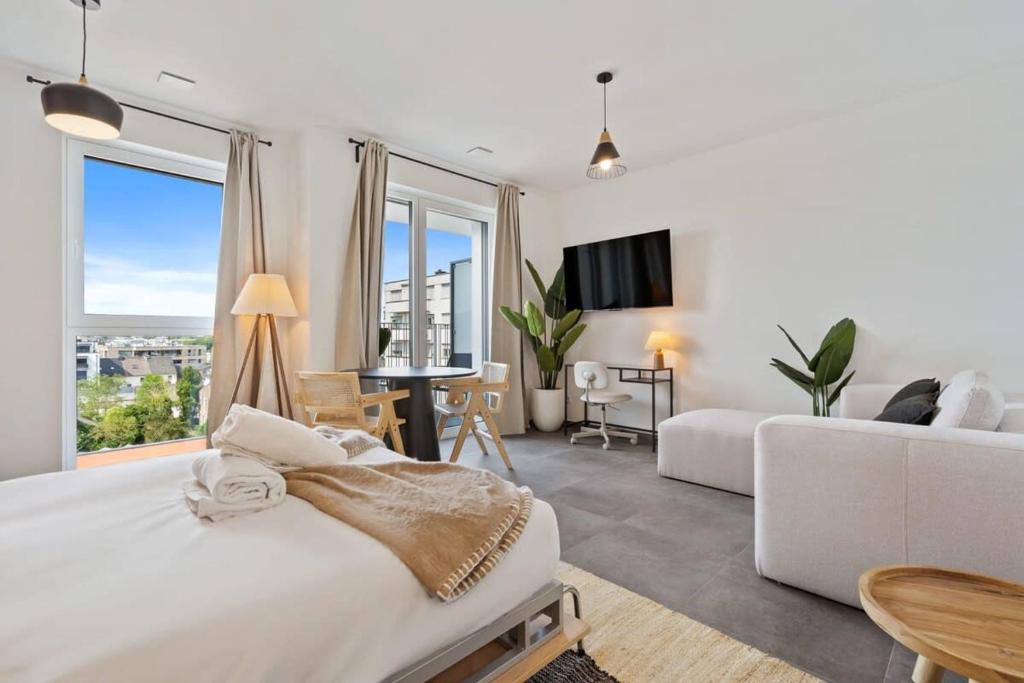 ein weißes Schlafzimmer mit einem großen Bett und einem Sofa in der Unterkunft Premium City Stay in Cessange ID204 in Luxemburg (Stadt)