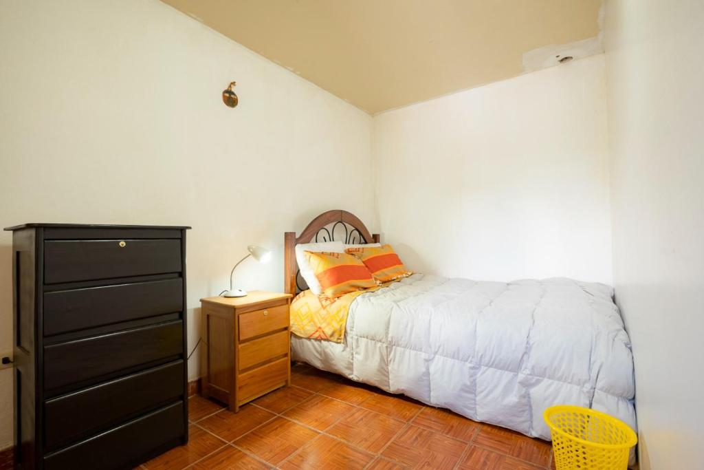 een kleine slaapkamer met een bed en een dressoir bij Emilia house in Urubamba